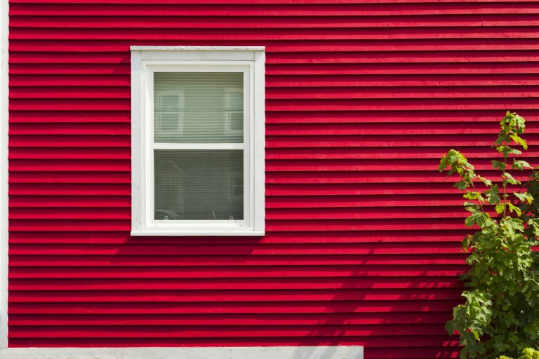 Side of a house with red vinyl siding