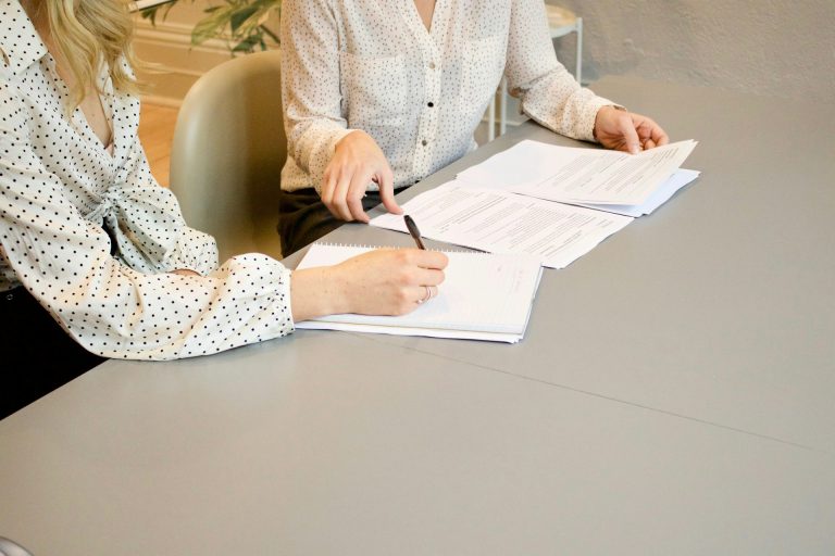 two women collaborating at a gray table