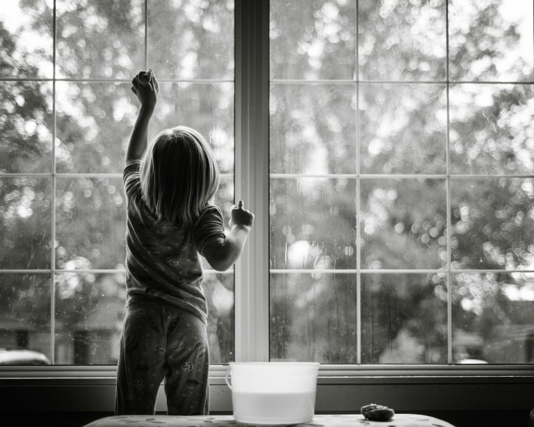 small child cleaning a window