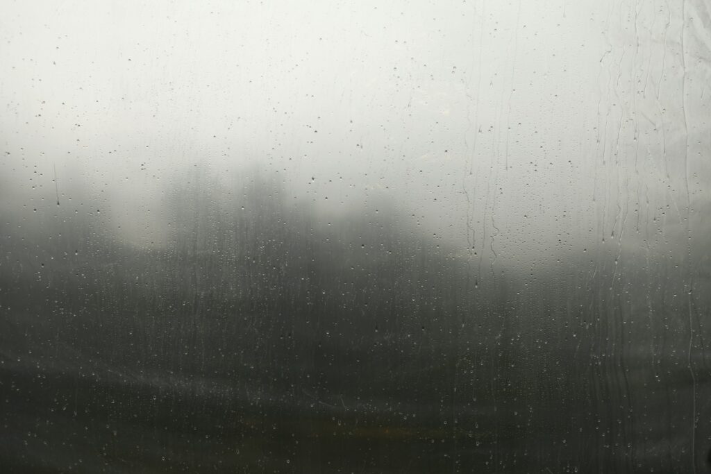 View of a landscape through a window with heavy condensation